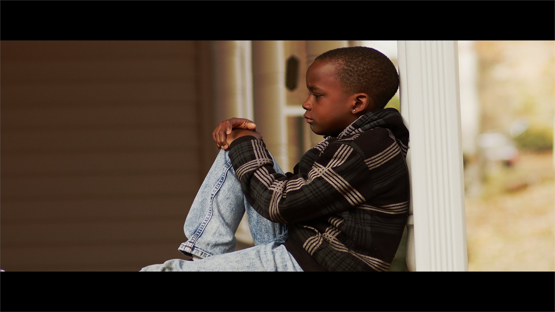 A child sitting on a porch